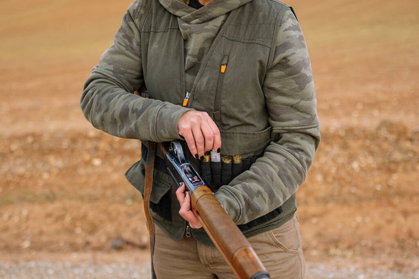 Hunter woman with shotgun hunting in the field. - Фото, изображение