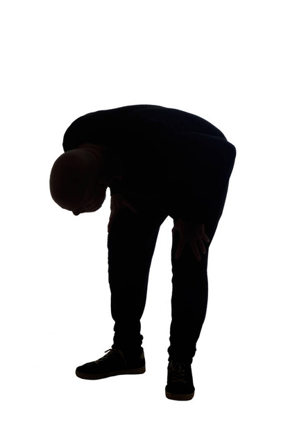 σιλουέτα ενός άνδρα που ψάχνει πάτωμα ψάχνοντας σε λευκό φόντο - Φωτογραφία, εικόνα