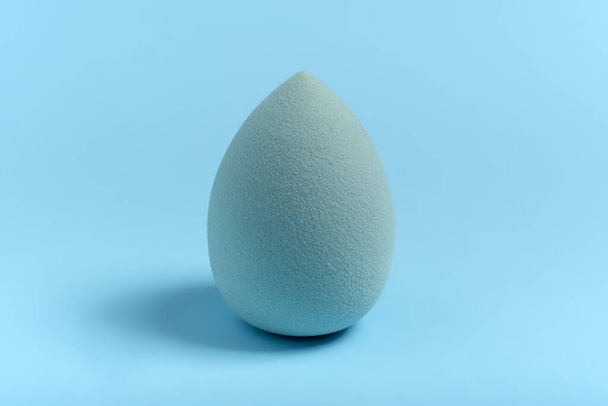Blue cosmetic makeup sponge on a minimal background. Egg shape. Tool for applying foundation cream. Nobody. - Fotó, kép