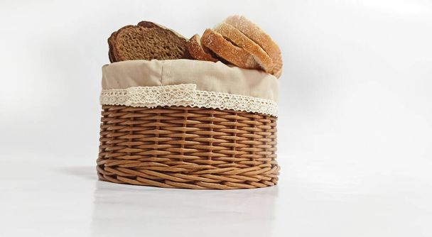 Vine wicker basket isolated on white background. Bread basket. Pieces of bread in a bread basket. Bread box made of vine. Side view - Valokuva, kuva