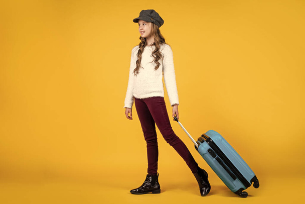 happy kid in cap with travel bag suitcase, traveling - Foto, imagen