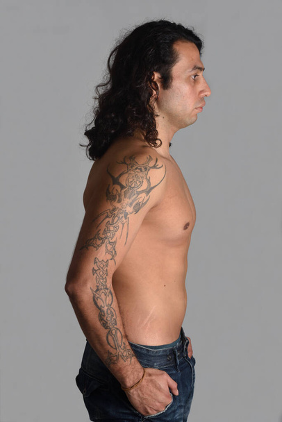 profil portré egy férfi tetovált szürke háttér - Fotó, kép