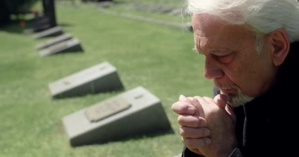 Surullinen vanha harmaa tukkainen mies rukoilee haudalla hautausmaalla, surua ja surua läheisten ihmisten menettämisestä, 4k 60p Prores - Materiaali, video