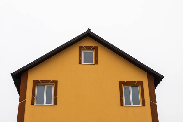 Крыша дома выполнена из красной металлической плитки, красивый большой дымоход. - Фото, изображение