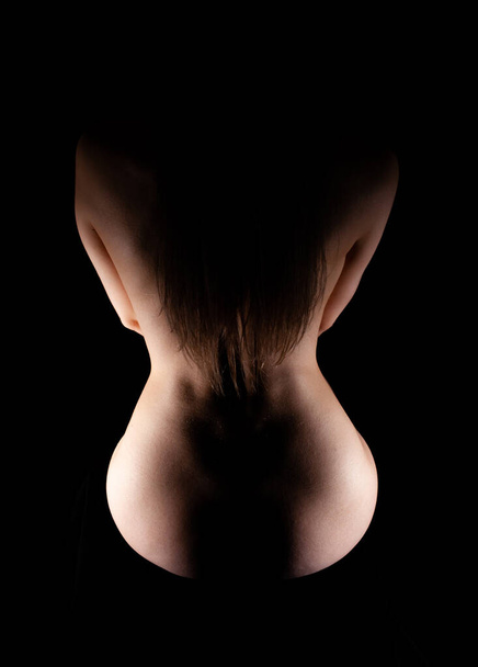 silhouette of a slender woman from the back on a black background - Valokuva, kuva