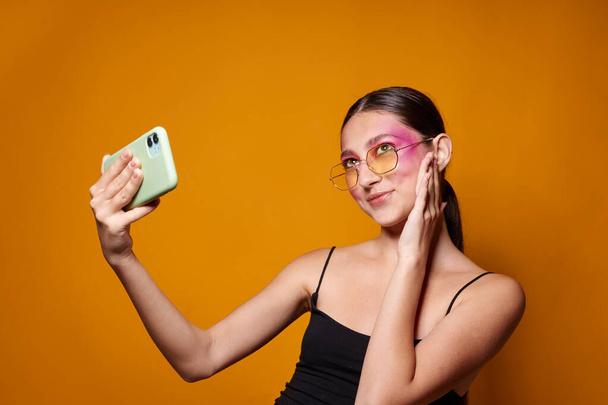 Sexy brunette woman smile bright pink makeup emotions cosmetics smartphone selfie close-up unaltered - Valokuva, kuva