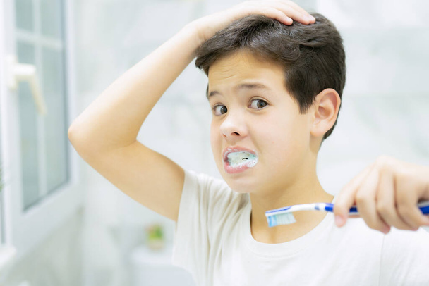 Kid brushing teeth with brush in bathroom. Dental hygiene every day. Health care, childhood and dental hygiene. - Φωτογραφία, εικόνα