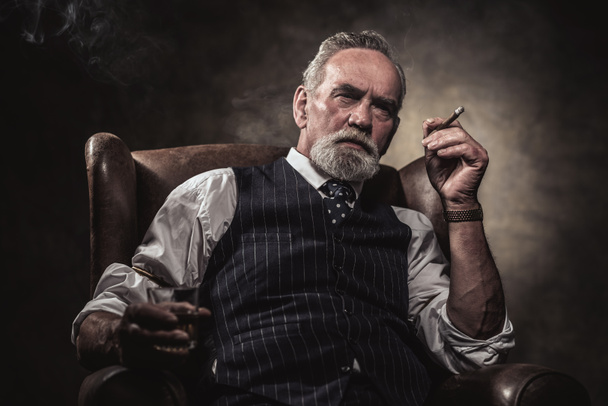 В кресле сидит старший бизнесмен с сигарой и виски. Грей
 - Фото, изображение