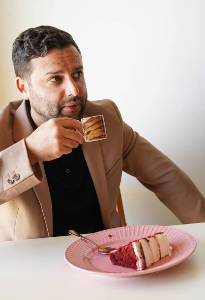 Man enjoying red velvet cake and coffee on work break - Foto, Imagem