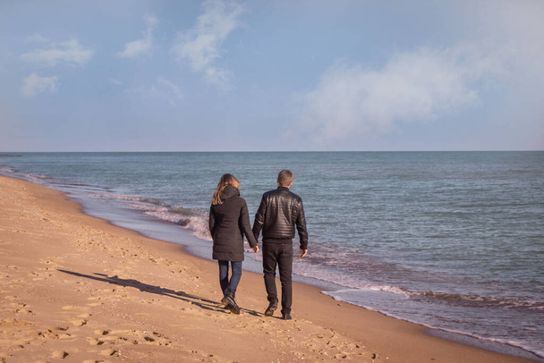a couple of lovers walk along the seashore, love story - Foto, imagen