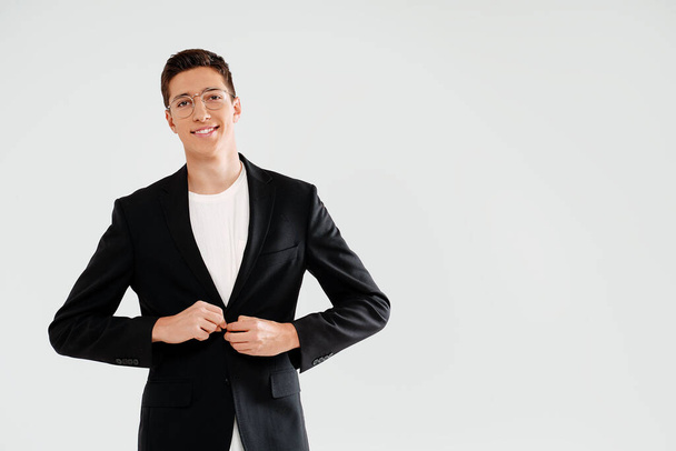 Young handsome businessman in elegant clothes and eyeglasses smiling, looking at the camera. Happy student. A lot of copy space. - Фото, изображение