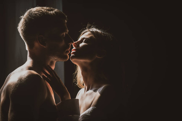 Passionate kiss. Portrait of lovely couple in love. Young sensual girlfriend glad to passionate kiss from her boyfriend. Handsome man embraces his woman and kisses. - Photo, Image