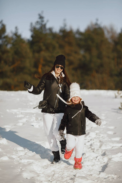 Mother and child in winter clothes play in winter park - Foto, imagen