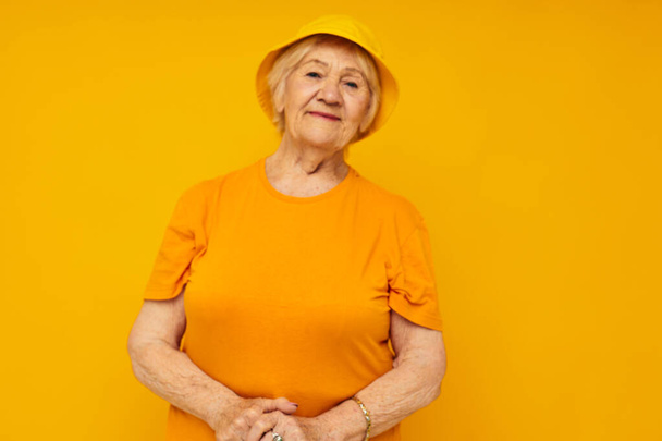 elderly woman in casual t-shirt yellow panama isolated background - Zdjęcie, obraz