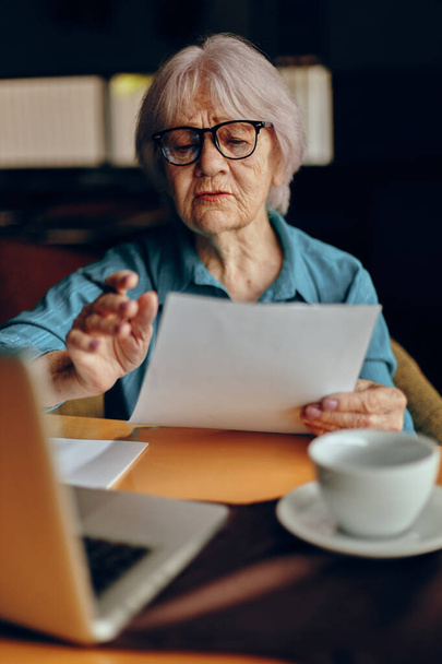 Gyönyörű érett idős nő dolgozik előtt laptop monitor ül Nyugdíjas nő csevegés változatlan - Fotó, kép