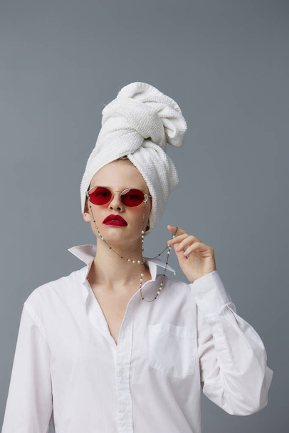 mujer con una toalla en la cabeza en una camisa blanca modelo de estudio inalterada - Foto, imagen