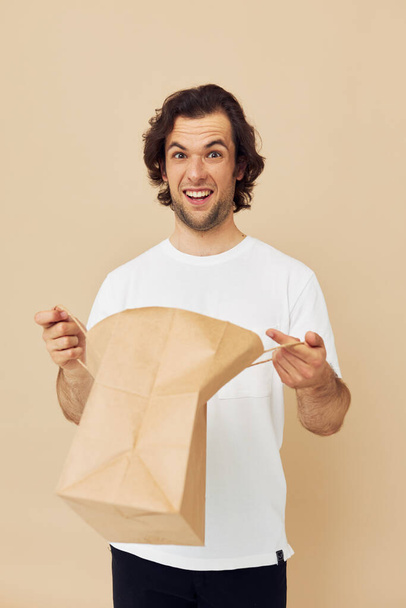 Attractive man paper bag emotions posing Lifestyle unaltered - Foto, immagini