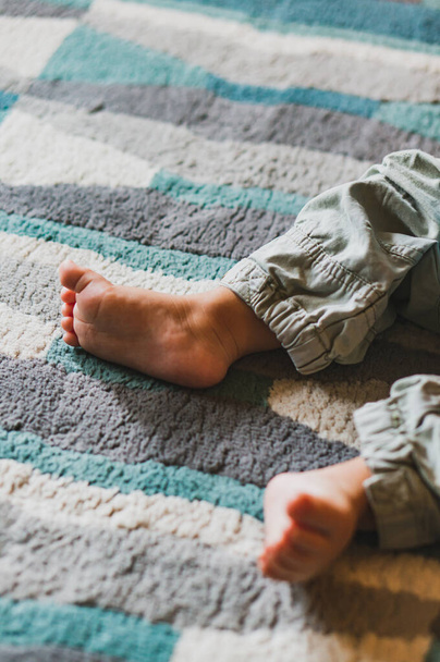 feet of a baby boy lying on the floor - 写真・画像
