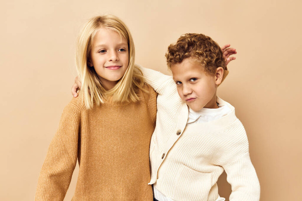 kleine kinderen glimlachen en poseren in casual kleding beige achtergrond - Foto, afbeelding