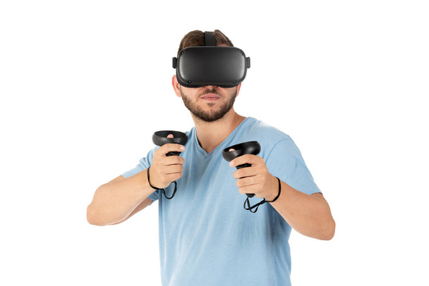Beyaz arka planda VR gözlükleriyle oynayan genç adama yaklaş. - Fotoğraf, Görsel
