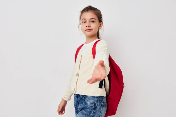 little girl hand gesture red backpack light background - Foto, Bild
