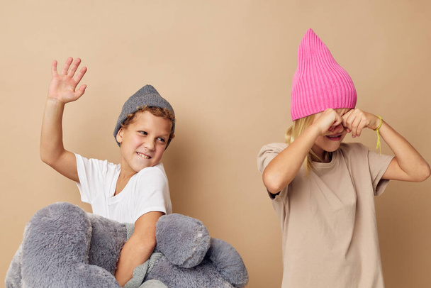 Photo of two children in hats with a teddy bear friendship Lifestyle unaltered - Φωτογραφία, εικόνα