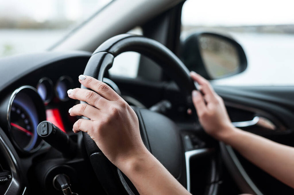 Women's hands on the steering wheel, inside the car. Taken in close-up, in the car. - Fotografie, Obrázek