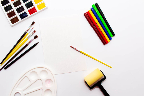Row of artist paintbrushes, watercolor paints, palette, felt-tip pens for drawing - 写真・画像