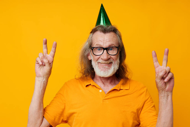 Senior grey-haired man fun birthday cap on the head isolated background - Fotografie, Obrázek