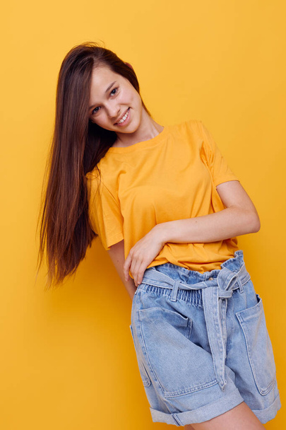 optimistic young woman fashion in yellow t-shirt denim shorts Lifestyle unaltered - Fotó, kép