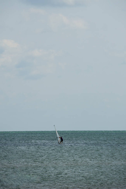 Purjelautailu. Surffaaja treenaa tyynessä meressä tai valtameressä. Virkistysvesiurheilu idyllisen kesäloman aikana - Valokuva, kuva