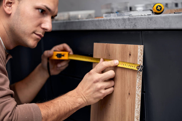 Handyman making kitchen wall cabinets in the apartment. - 写真・画像