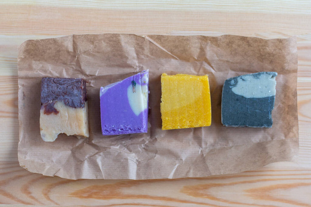 Natural handmade soap. Pieces of multicolored soap made of natural materials on the table - Foto, Imagem