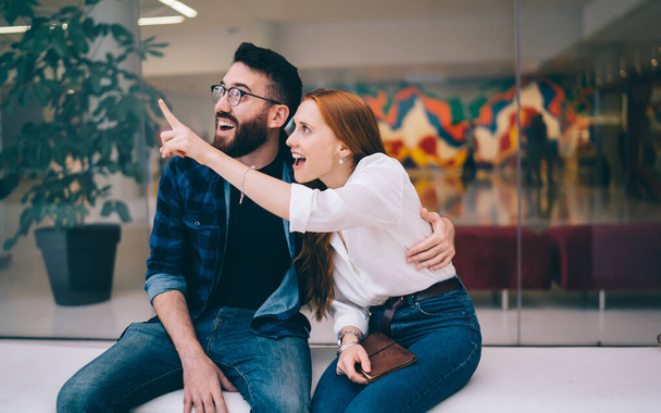 Shocked Caucasian couple in love 20s discussing something feeling amazed during together leisure time, happy impressed male and female in casual clothing wondering during date flirting indoors - Photo, image