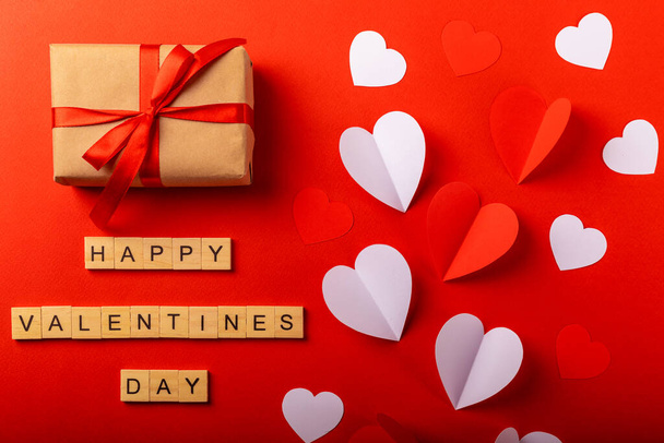 Valentijnsdag. Inscriptie Happy Valentine 's Day, Rode en witte hartjes, handgemaakte geschenkdoos op een rode achtergrond. Begrepen, ruimte. Vakantie en liefde concept. - Foto, afbeelding