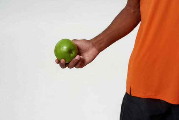 Cropped of black man holding green organic apple - Foto, immagini
