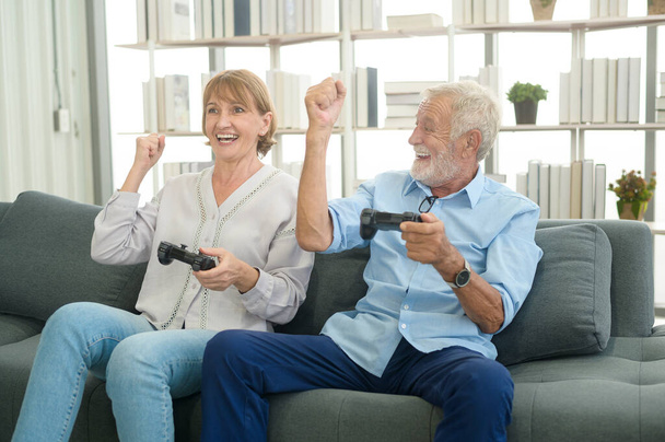 Happy Caucasian senior couple playing games at home - Foto, imagen