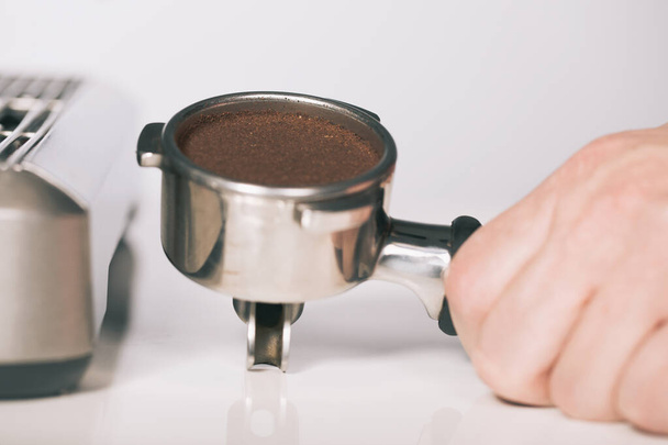 Pressing ground coffee in handle for extracting in espresso machine - Photo, Image