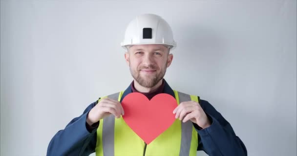 Supervisor in helmet showing red heart for Valentines Day - Filmagem, Vídeo