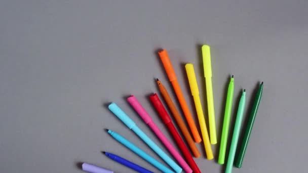 Marcadores de colores brillantes sobre un fondo gris neutro - Metraje, vídeo