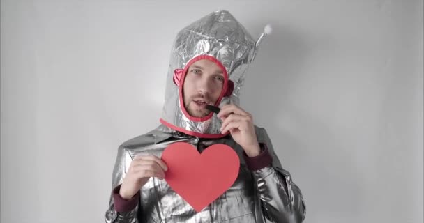 Valentines day concept: spacesuit male with red paper heart - Video