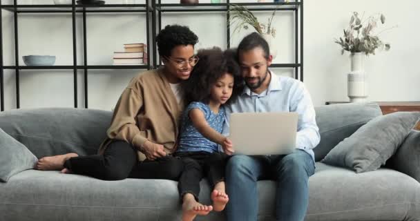 Young African couple and little daughter use laptop discuss purchase - Video, Çekim
