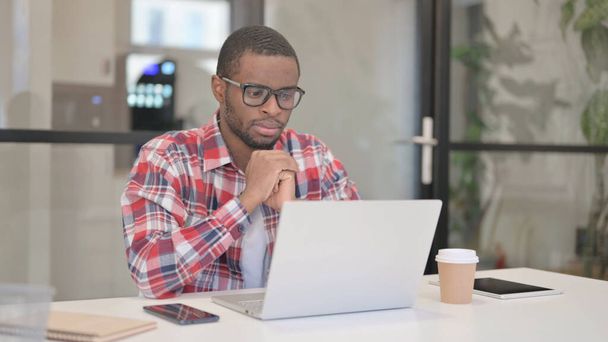 Африканський чоловік думає під час роботи на ноутбуці
 - Фото, зображення