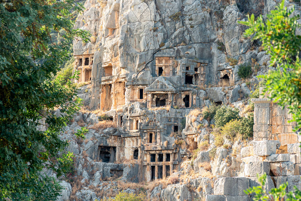 αρχαίοι πέτρινοι τάφοι στην πλαγιά του βουνού πάνω από την αρχαία πόλη Μίρα στη Ντεμρέ της Τουρκίας - Φωτογραφία, εικόνα