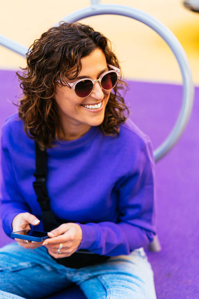 Cheerful girl in headphones using smartphone - Fotografie, Obrázek