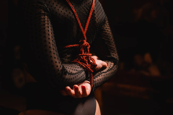 Young woman with her hands tied behind her back, close-up. High quality photo - Photo, Image