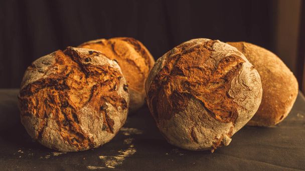 frissen sült falusi kenyér különféle összetevőkkel, mint a búza, rozs és gesztenye - Fotó, kép