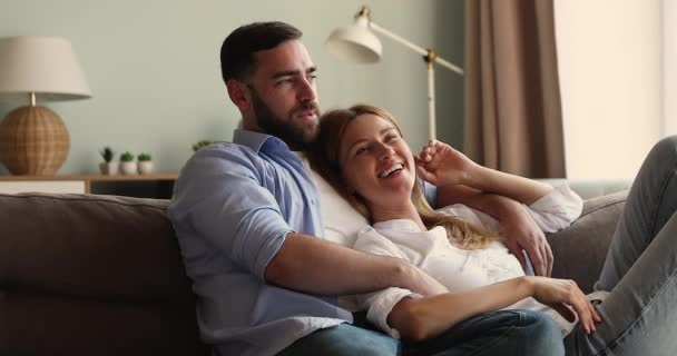 Affectionate young family couple share dreams resting on sofa - Video