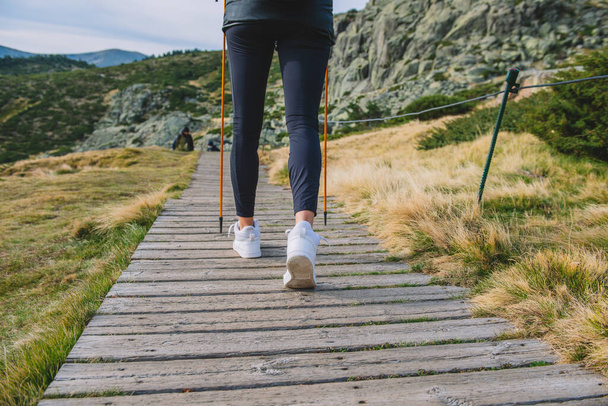 vrouw wandelen van de berg met palen - Foto, afbeelding