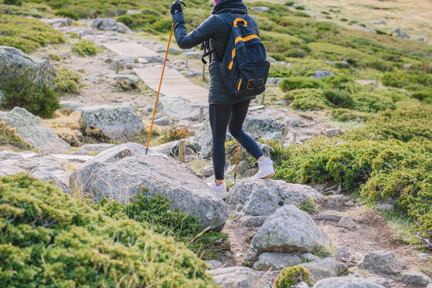 Nainen kävelee alas vuorta pylväiden kanssa - Valokuva, kuva